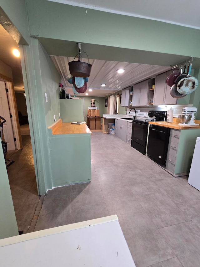 kitchen featuring black range with electric cooktop, sink, and kitchen peninsula