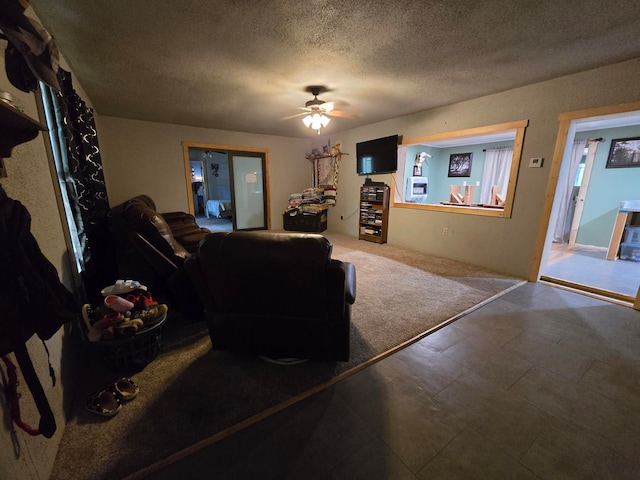 living room with ceiling fan and a textured ceiling