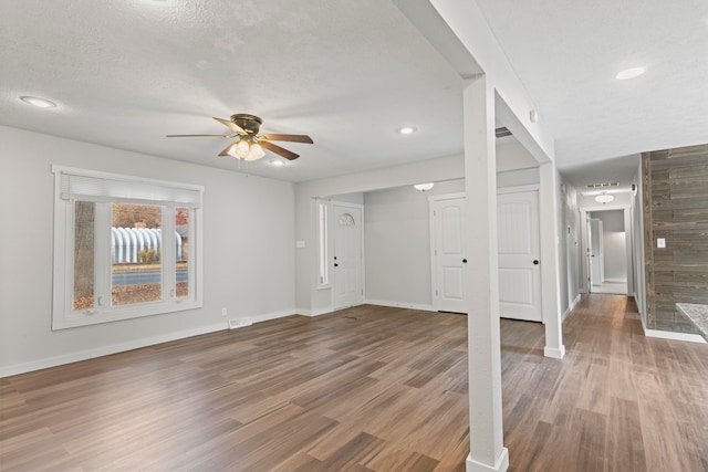 unfurnished living room featuring hardwood / wood-style floors, a textured ceiling, and ceiling fan