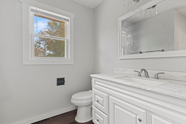 bathroom featuring vanity, hardwood / wood-style flooring, and toilet