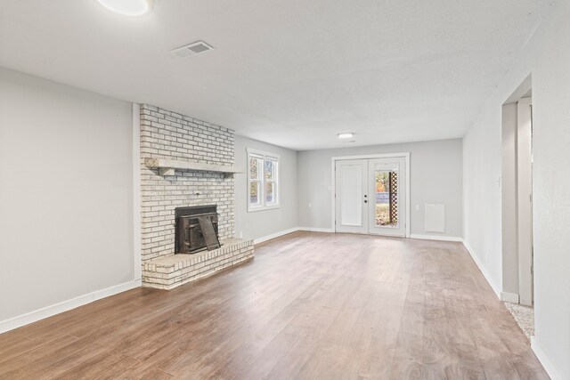 unfurnished living room featuring a brick fireplace and wood-type flooring