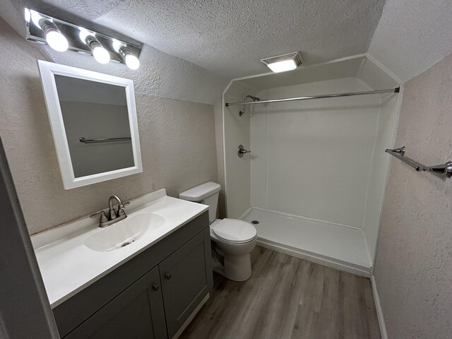 824 W Elm St, Springfield, MO 65806 - full bathroom featuring a textured wall, a textured ceiling, wood finished floors, vanity, and a shower