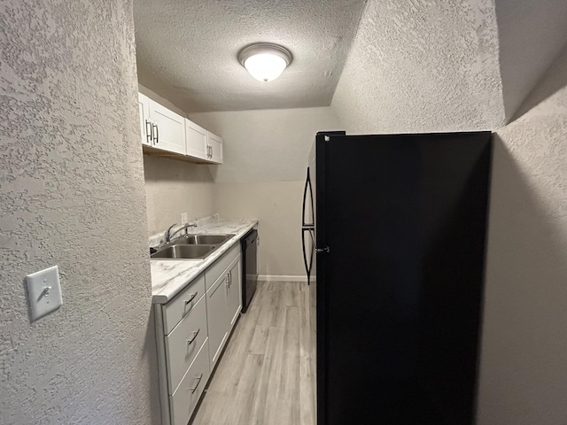 824 W Elm St, Springfield, MO 65806 - kitchen featuring a textured wall, black appliances, a textured ceiling, light countertops, and light wood finished floors