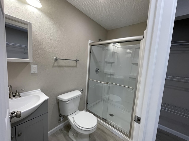 824 W Elm St, Springfield, MO 65806 - full bathroom featuring vanity, a stall shower, a spacious closet, and wood finished floors