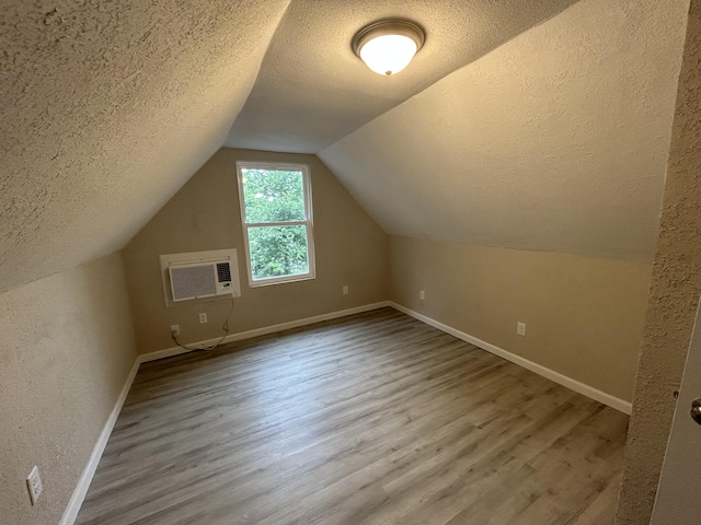 824 W Elm St, Springfield, MO 65806 - additional living space featuring a textured ceiling, wood finished floors, a wall mounted air conditioner, and lofted ceiling