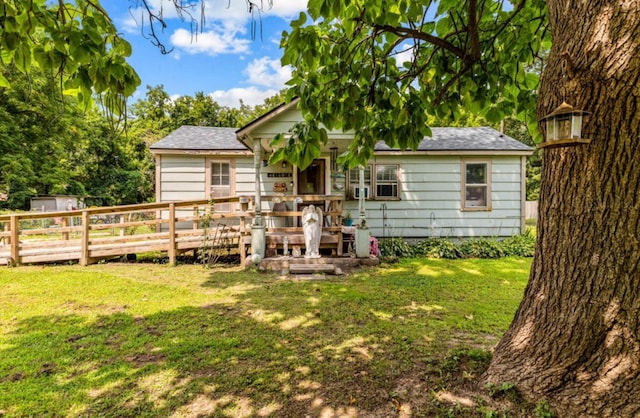 rear view of house featuring a wooden deck and a yard