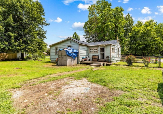 back of property featuring a wooden deck and a lawn