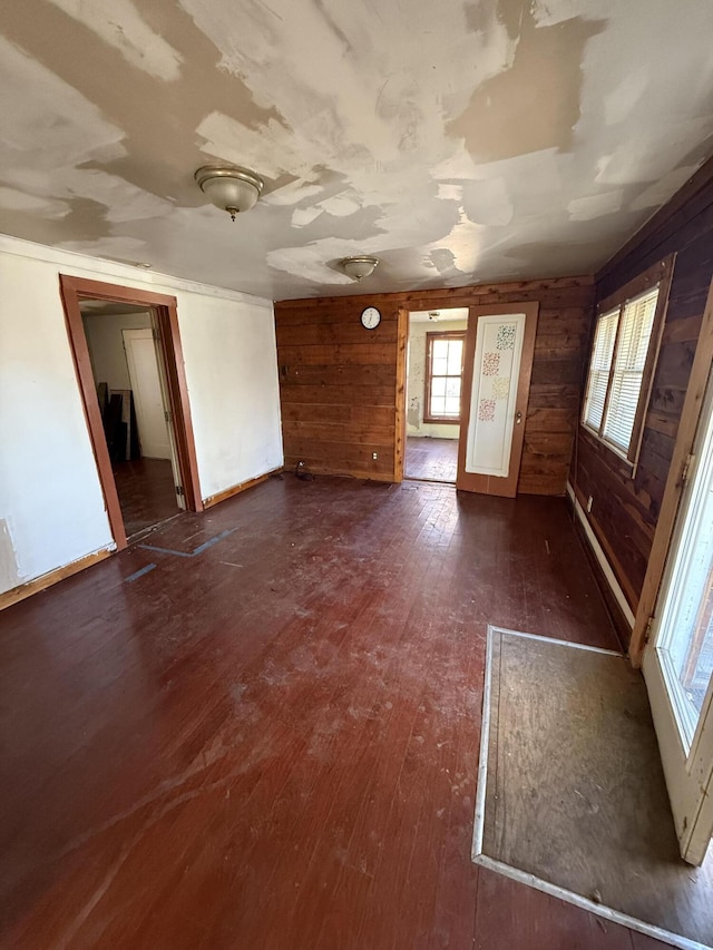 unfurnished room with dark hardwood / wood-style flooring and wooden walls