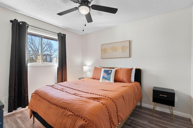 bedroom featuring ceiling fan, a textured ceiling, and dark wood-type flooring