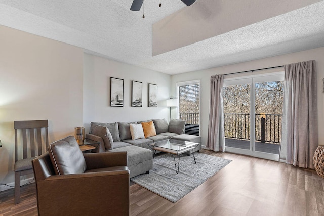 living room with ceiling fan, hardwood / wood-style floors, and a textured ceiling