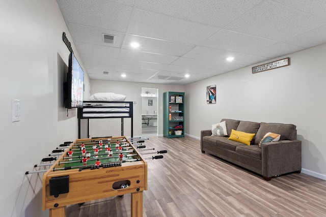 recreation room with wood-type flooring and a drop ceiling