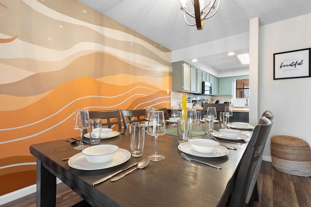 dining room featuring a notable chandelier, a textured ceiling, and dark wood-type flooring