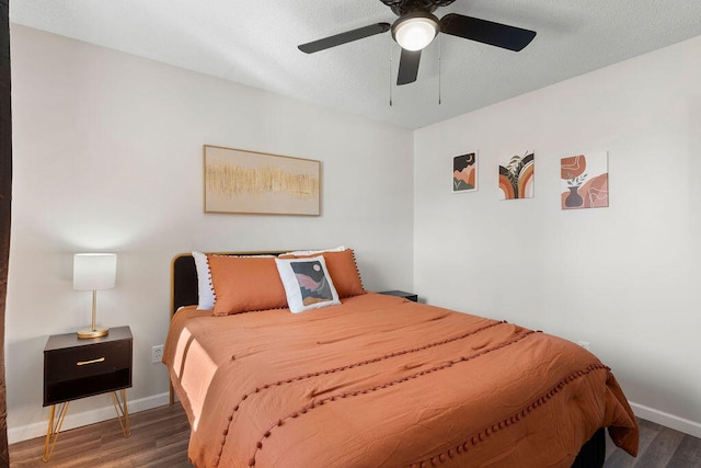 bedroom featuring dark hardwood / wood-style flooring, a textured ceiling, and ceiling fan