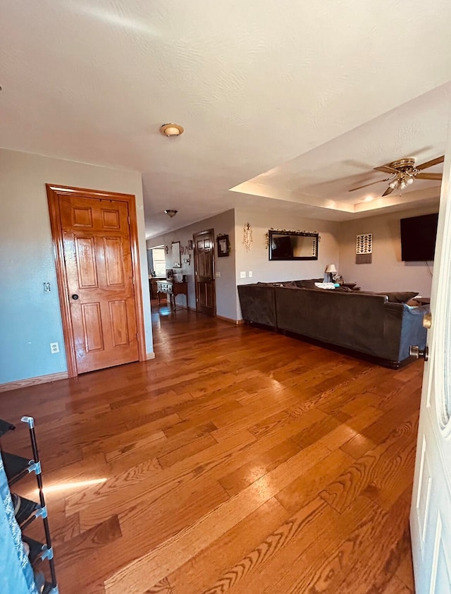 unfurnished living room featuring ceiling fan and wood-type flooring