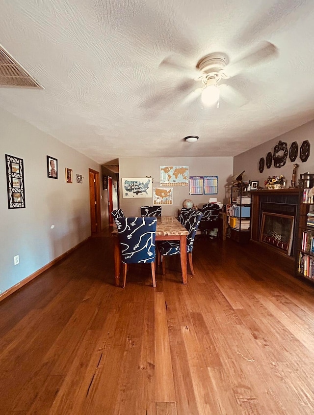 dining room with wood-type flooring, a textured ceiling, and ceiling fan