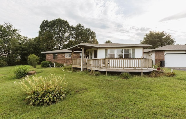 rear view of property with a wooden deck, a lawn, brick siding, and aphalt driveway