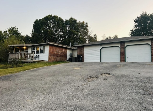ranch-style home featuring a garage, cooling unit, and brick siding