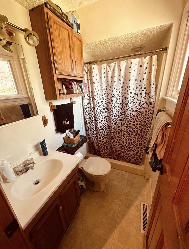 full bathroom with visible vents, curtained shower, tile patterned flooring, and vanity