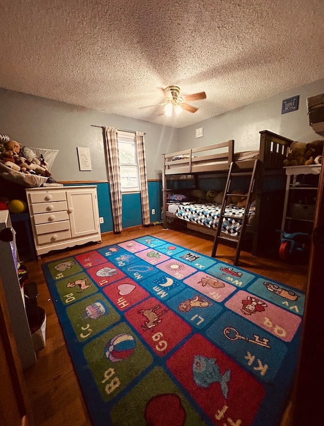 bedroom featuring ceiling fan, a textured ceiling, and dark wood-type flooring