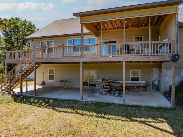 rear view of property with a deck, a lawn, and a patio area