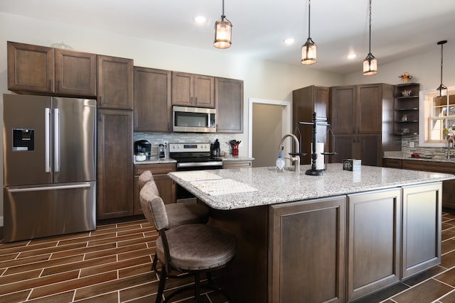 kitchen with dark brown cabinetry, appliances with stainless steel finishes, hanging light fixtures, and dark wood-type flooring