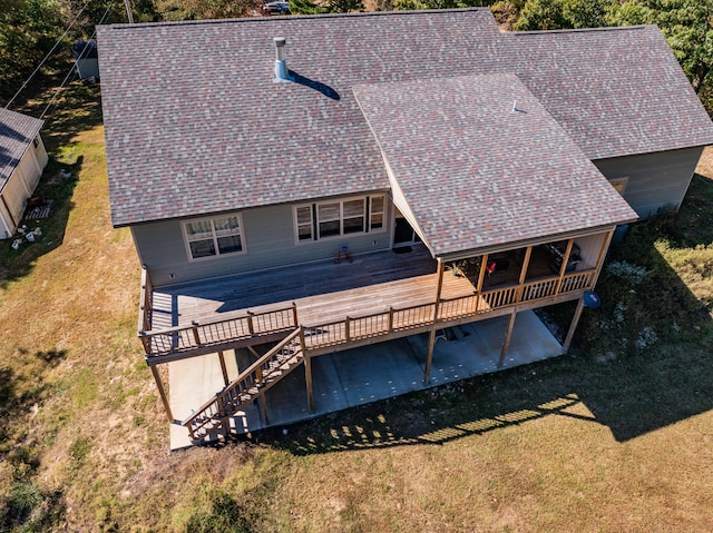 back of property with a wooden deck and a lawn