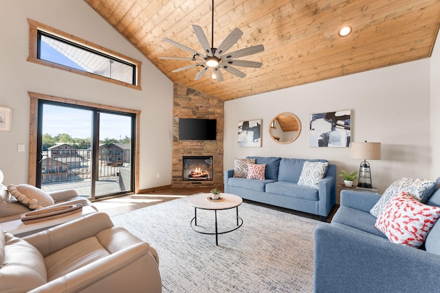 living room with ceiling fan, high vaulted ceiling, hardwood / wood-style flooring, wooden ceiling, and a fireplace