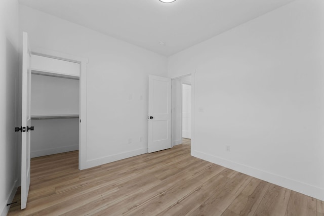 unfurnished bedroom featuring a closet and light hardwood / wood-style flooring