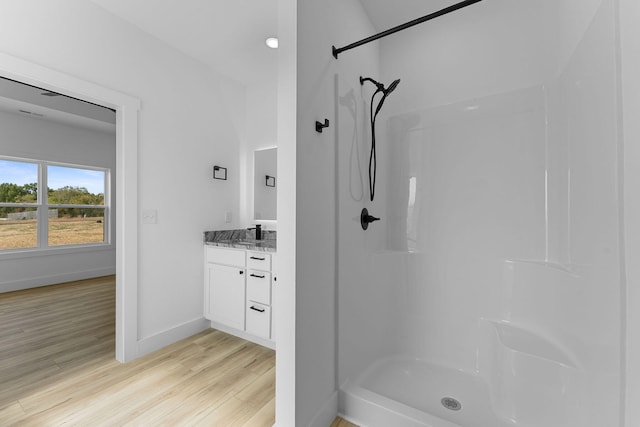 bathroom featuring a shower, hardwood / wood-style flooring, and vanity