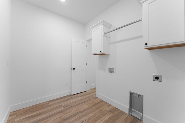 clothes washing area with hookup for a washing machine, cabinets, hookup for an electric dryer, and light hardwood / wood-style flooring