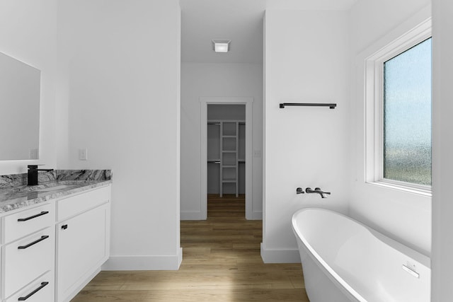 bathroom featuring hardwood / wood-style flooring, vanity, and a bathing tub