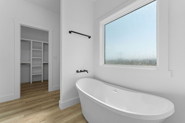 bathroom with wood-type flooring and a washtub