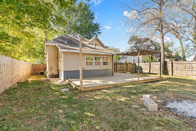 back of house with a wooden deck and a lawn