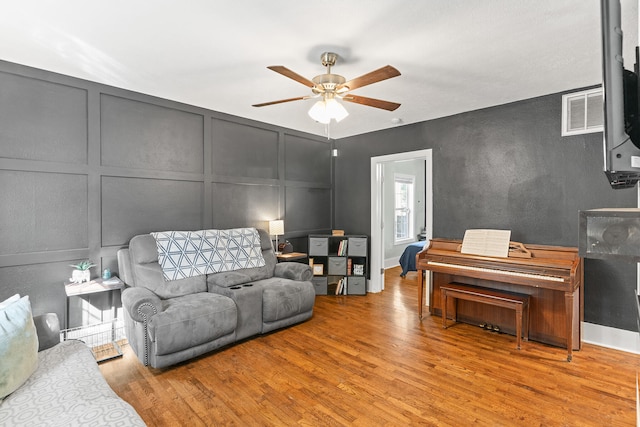 living room with ceiling fan and light hardwood / wood-style flooring