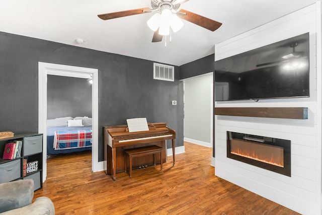 misc room with wood-type flooring and ceiling fan