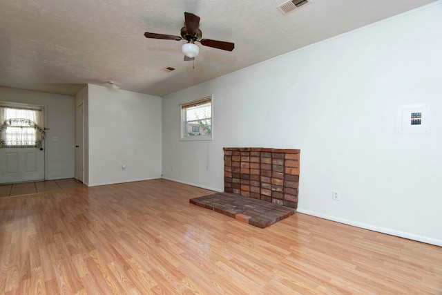 unfurnished living room with ceiling fan, a textured ceiling, and light hardwood / wood-style floors