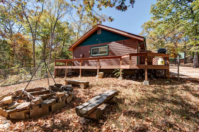 rear view of property with an outdoor fire pit and a deck