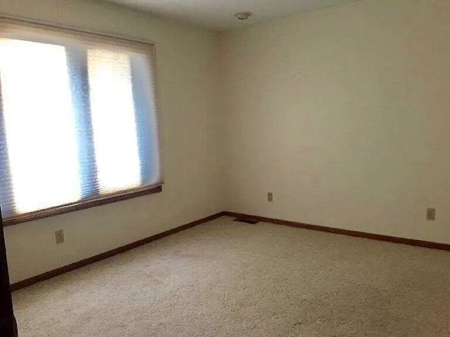 carpeted spare room with plenty of natural light