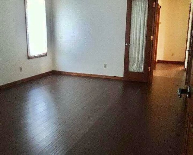 empty room with dark hardwood / wood-style flooring