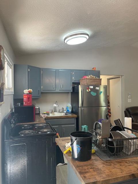 kitchen with black appliances, sink, and a textured ceiling