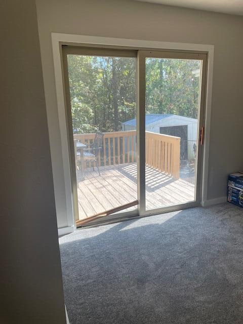 doorway to outside with a healthy amount of sunlight and carpet floors