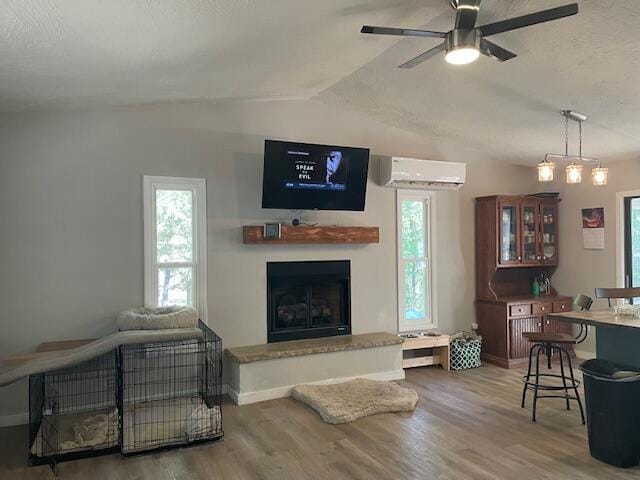 living room with hardwood / wood-style floors, a wealth of natural light, and vaulted ceiling