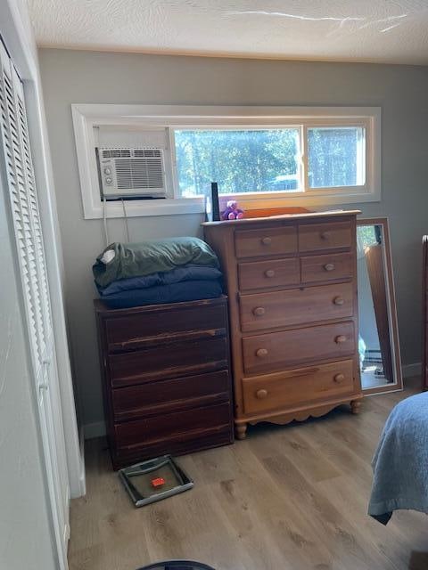 bedroom with a textured ceiling and light wood-type flooring