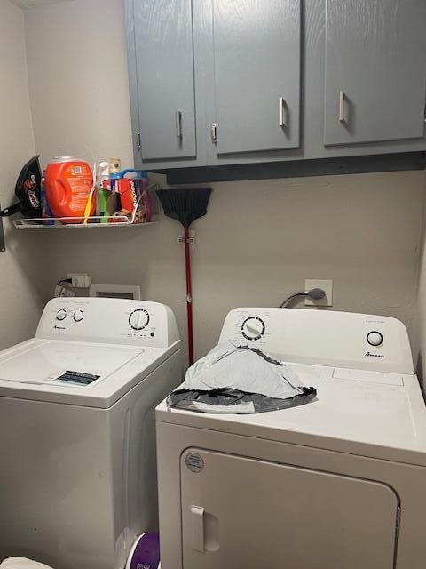 washroom with cabinets and washing machine and dryer