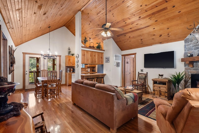 living room featuring light wood-type flooring, high vaulted ceiling, a fireplace, wooden ceiling, and ceiling fan with notable chandelier