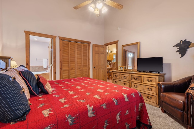 bedroom featuring a closet, light colored carpet, ensuite bathroom, and ceiling fan