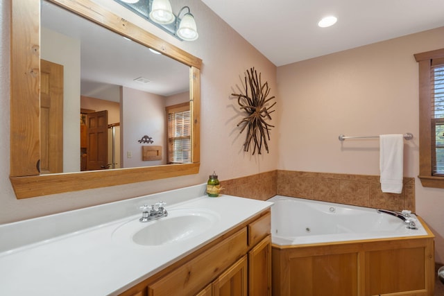 bathroom with vanity and a bath