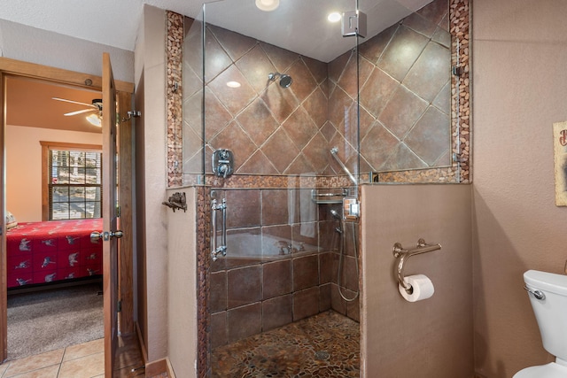 bathroom featuring an enclosed shower, ceiling fan, tile patterned floors, and toilet