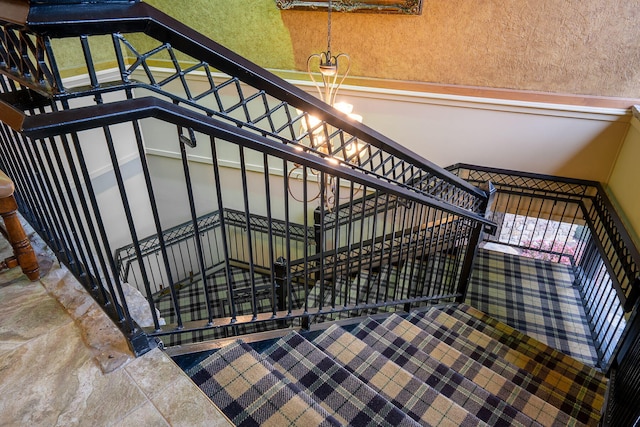 stairway featuring a chandelier