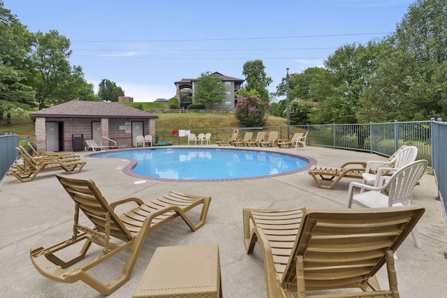 view of pool with a patio and an outbuilding